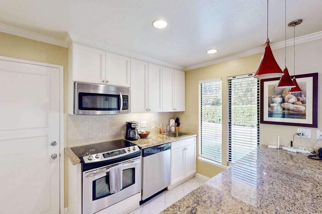 Prep your farm-to-table Napa Valley finds in a modern galley kitchen with granite countertops, stainless steel appliances, and crisp white cabinetry throughout.