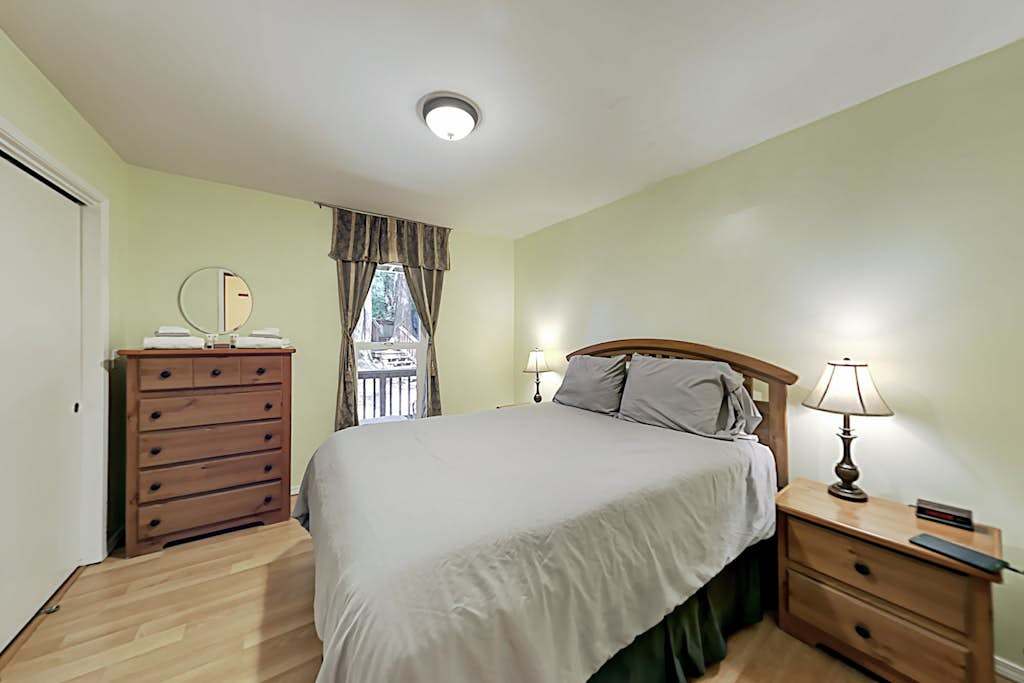 Drift off in your serene queen bedroom with bedside reading lamps and a wooden dresser — restful sleep to recharge for tomorrow's redwood adventures.