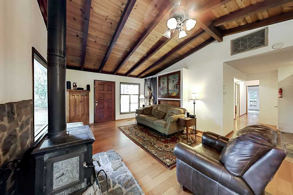 Gather around the stone-hearth wood stove after a day exploring Cazadero trails — leather seating and cathedral ceilings set a warm, lodge-like mood.