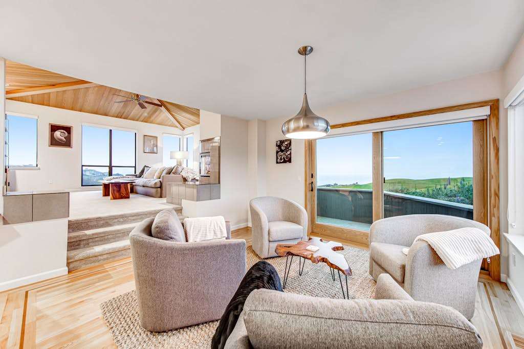 Settle into your sun-drenched living area where hardwood floors, modern furnishings, and floor-to-ceiling glass frame the Bodega Bay coastline