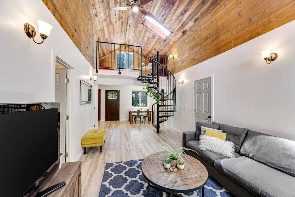 Take in the dramatic double-height living space — a striking spiral staircase leads to your private loft retreat above the redwood treetops.