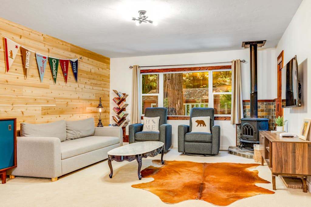Settle into your cozy living room with a wood-planked accent wall, cast-iron stove, and rustic bear-country touches after a day exploring Sonoma wine country.