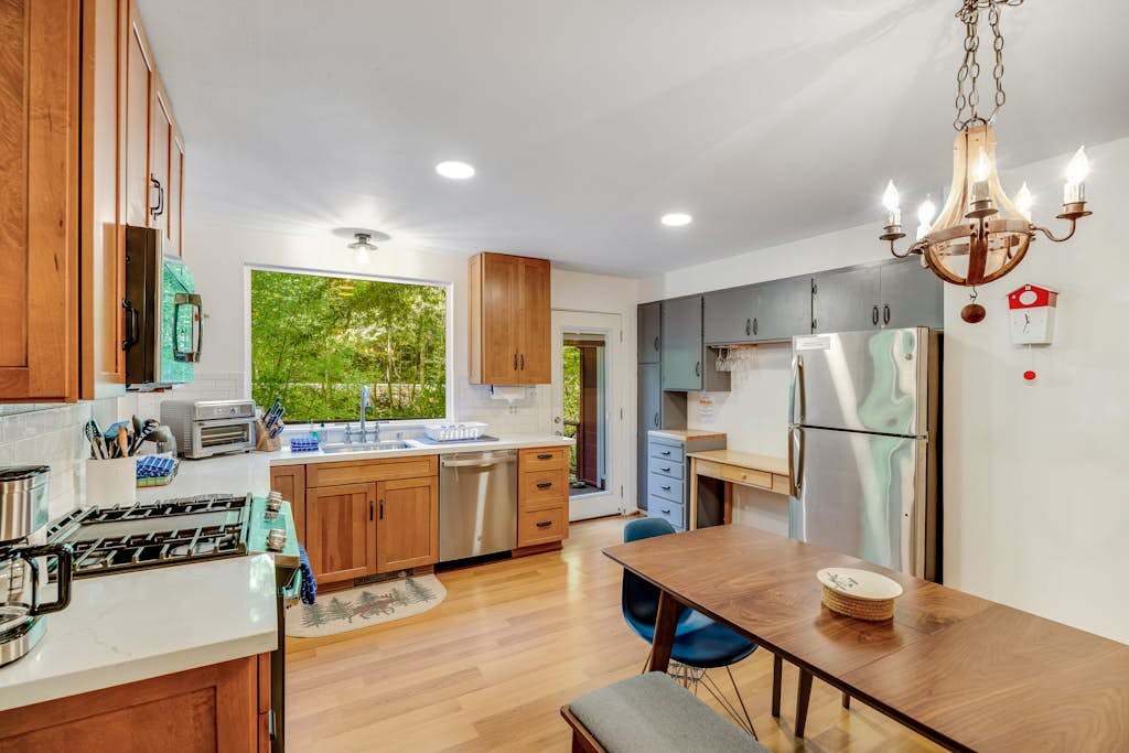 Everything you need to prepare a gourmet Cazadero dinner — gas range, stainless dishwasher, coffee maker, and leafy green views from the oversized window.