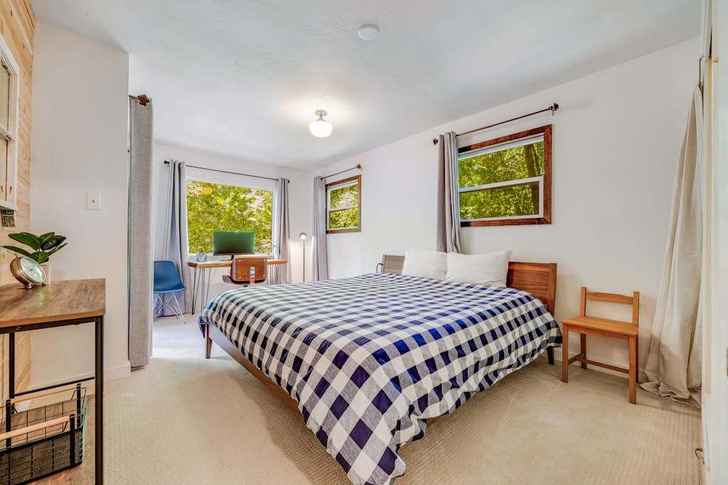 Two walls of windows fill your primary bedroom with soft forest light — sink into a king bed and let the stillness of Cazadero lull you to sleep.