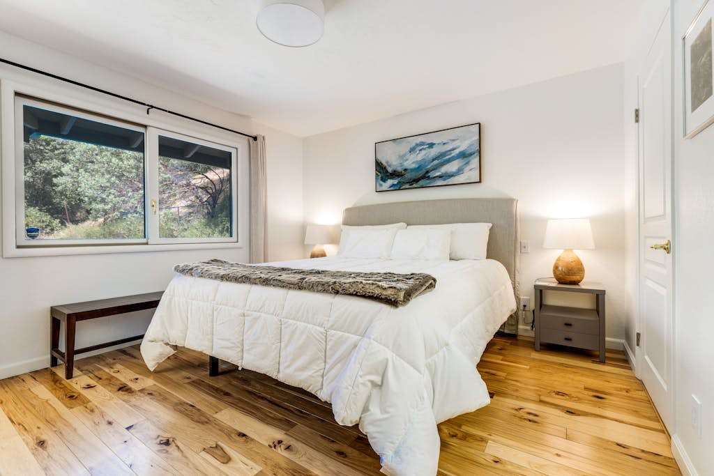 Stretch out in the king-size primary suite with an upholstered headboard, warm hardwood floors, and a luggage bench — your wine country sanctuary.