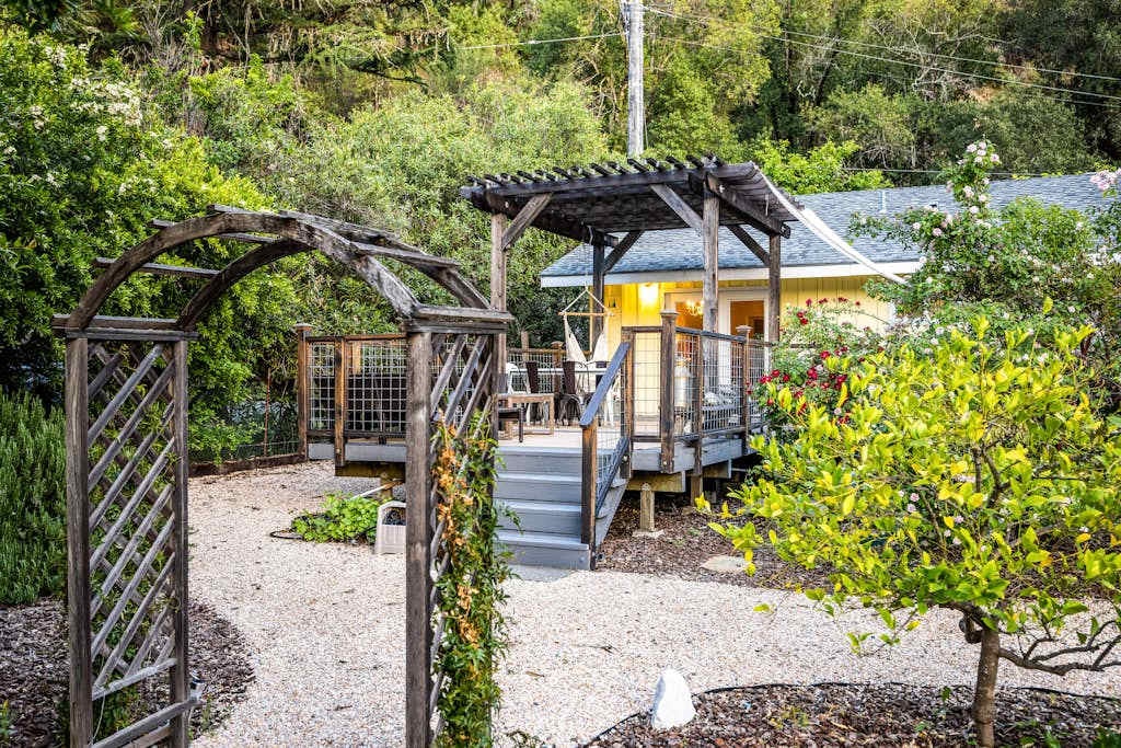 Step through your private vine-draped arbor into a storybook Cloverdale cottage tucked among lush gardens and towering trees