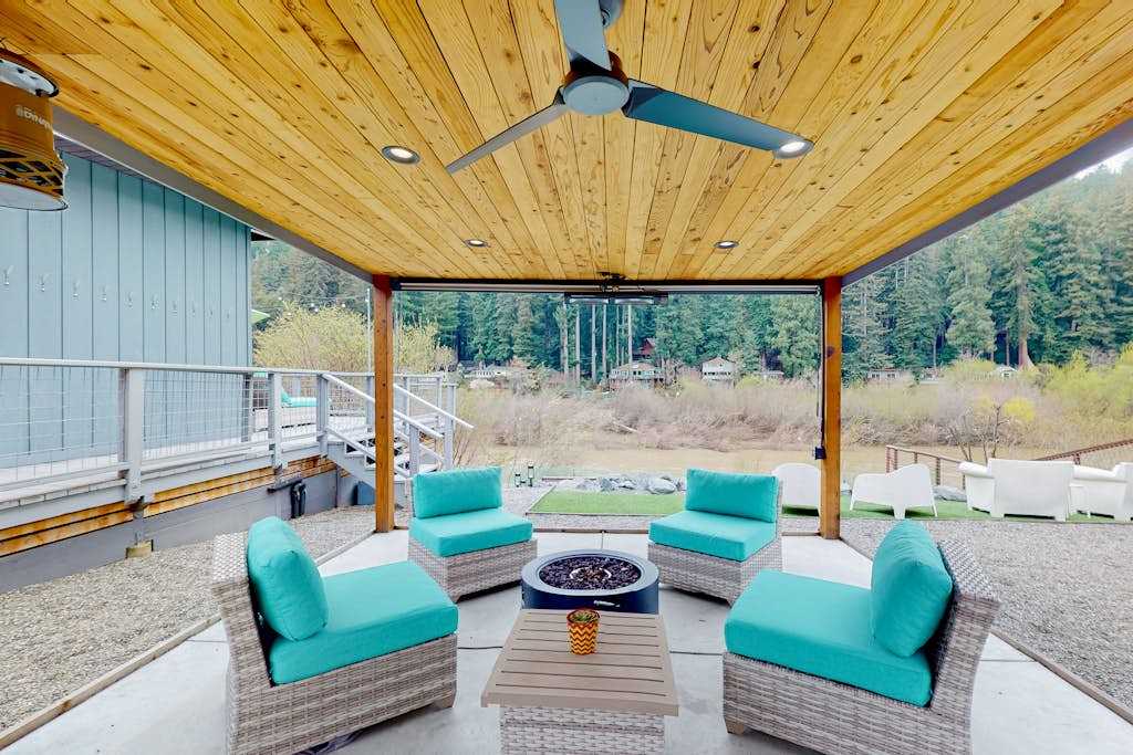 Unwind beneath your private covered pavilion with plush seating and a fire pit table — towering redwoods and the Russian River set the scene for unforgettable Monte Rio evenings.