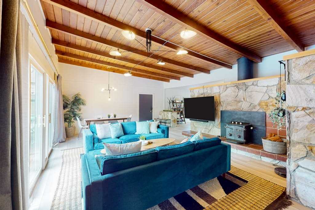 Cozy up for movie night with your group — a wall-mounted TV, dramatic stone accent wall, and track lighting make your living room the perfect redwood retreat gathering spot.