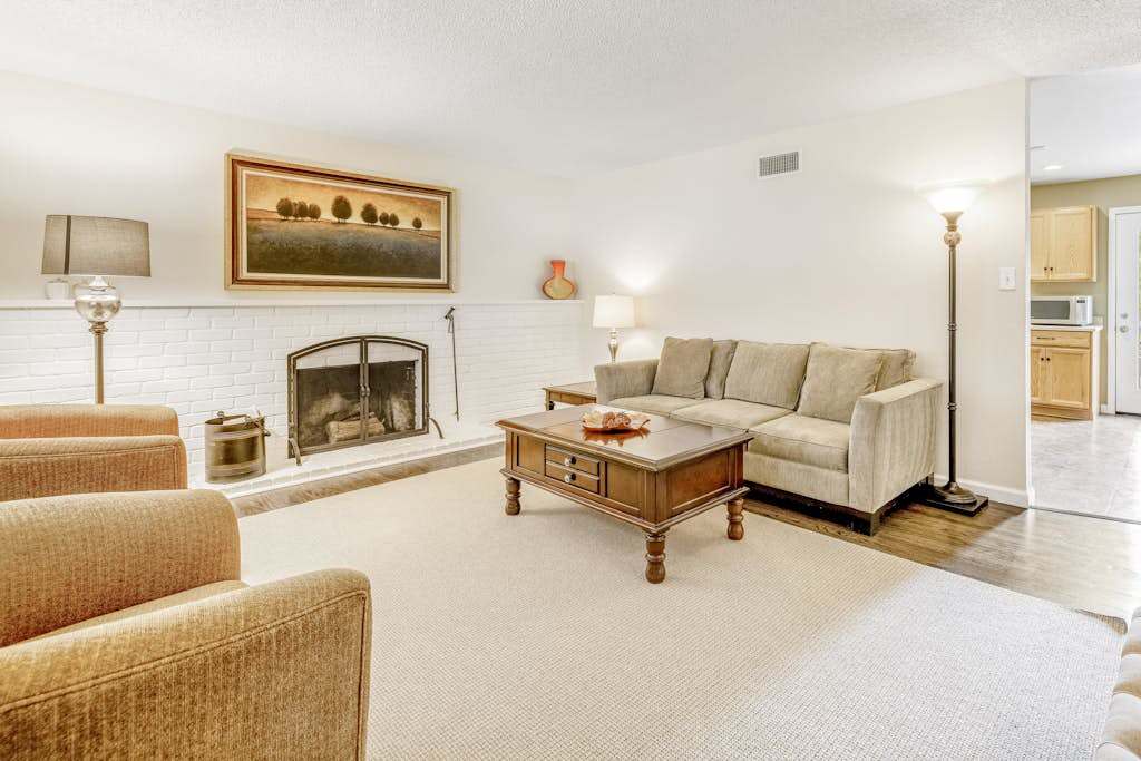 Sink into your cozy living room after a day of Kenwood wine tasting — a white brick fireplace, plush seating, and warm lighting set the scene for relaxing evenings.