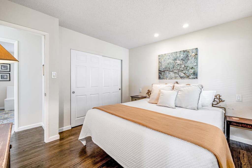 Retreat to your serene queen bedroom — warm gold accents, art-filled walls, and a generous closet give you a true home base in the heart of wine country.
