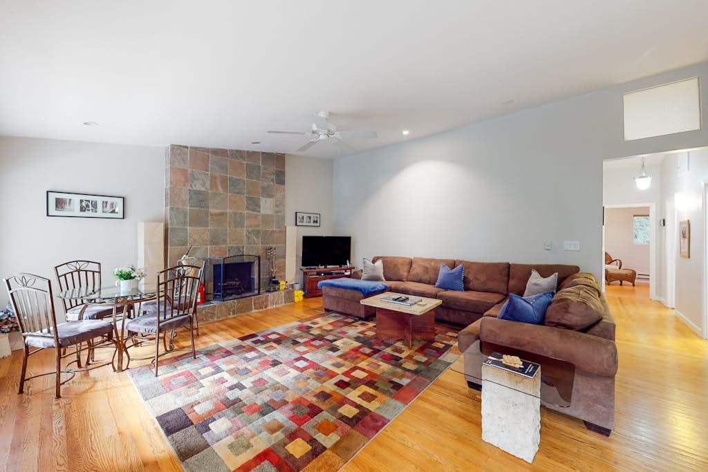 Settle into your spacious redwood retreat living room — a stone fireplace, plush sectional, and warm hardwood floors set the scene for cozy Russian River evenings after a day of wine tasting.