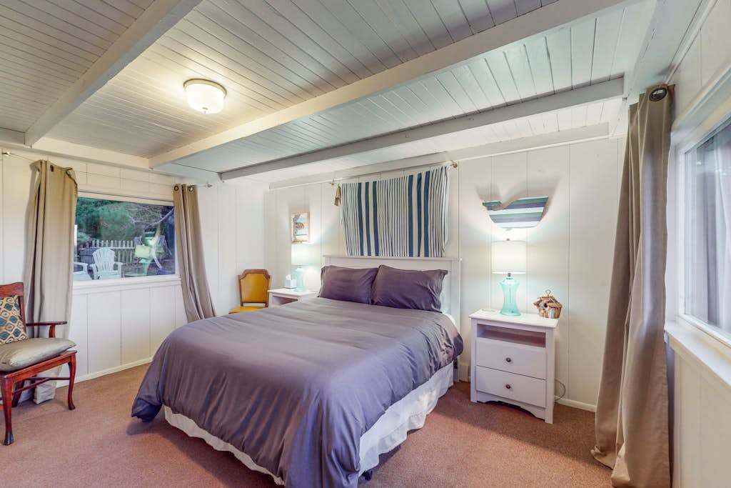 Drift off in your serene primary bedroom with a plush queen bed, vaulted beamed ceiling, and soft coastal tones — rest well after a day exploring Bodega Bay.