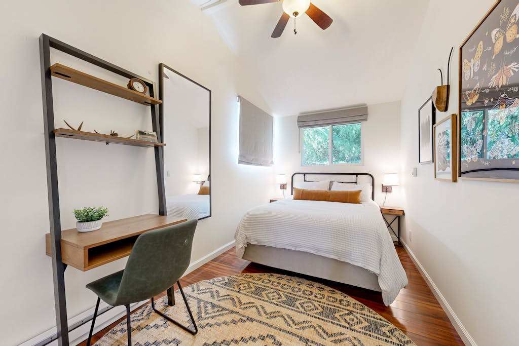 Recharge in your stylish guest bedroom featuring a queen bed, built-in desk workspace, and treetop views — ideal for catching up between Russian River adventures.