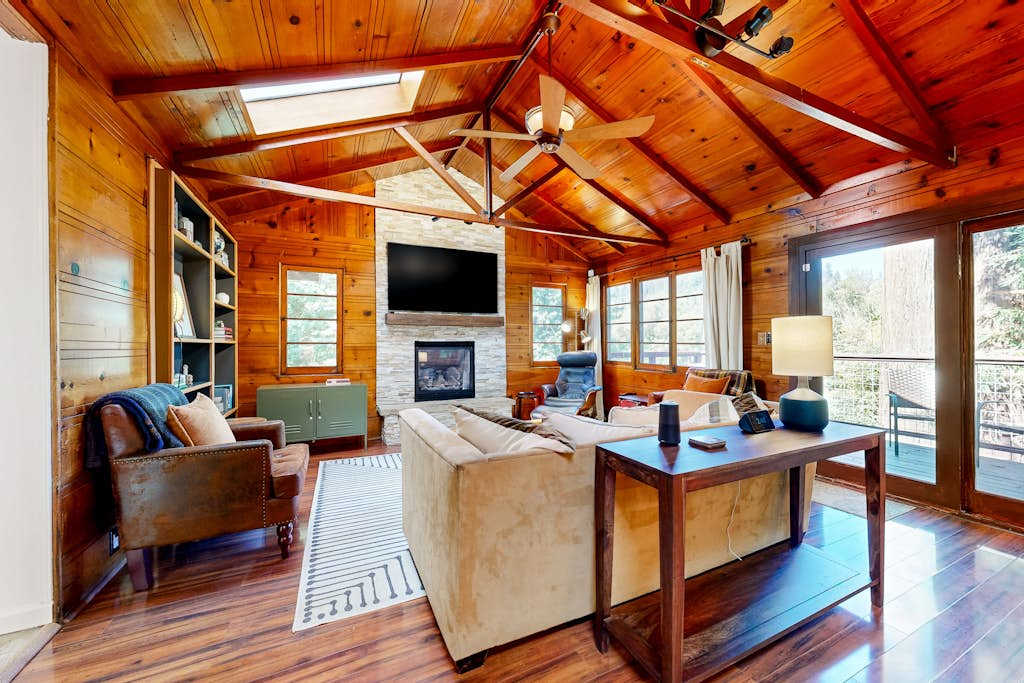 Settle into your warm, wood-paneled great room — vaulted knotty-pine ceilings, a stone fireplace, and flat-screen TV set the scene for wine country evenings along the Russian River.