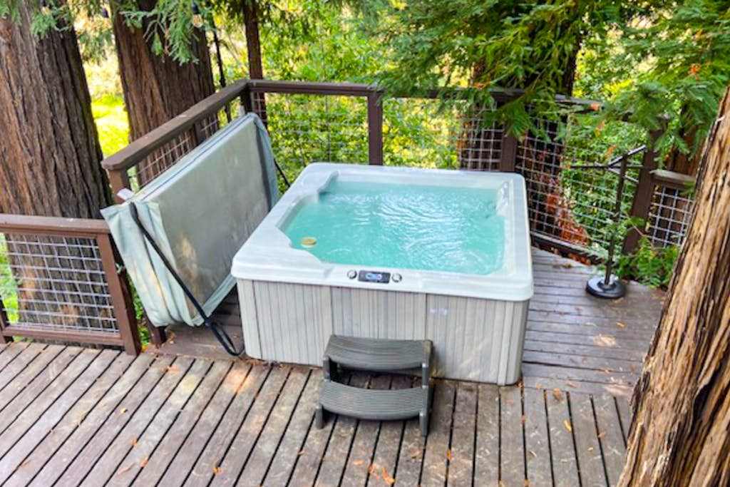 Slide into your bubbling private hot tub on the redwood deck — stars peek through the canopy as you recap your Forestville winery visits.