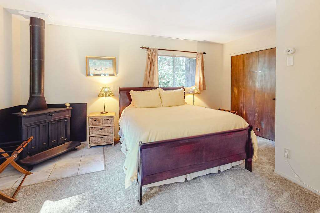 Cozy up beside the wood stove in your lower-level suite — a rich sleigh bed and warm tones make this your private redwood hideaway.