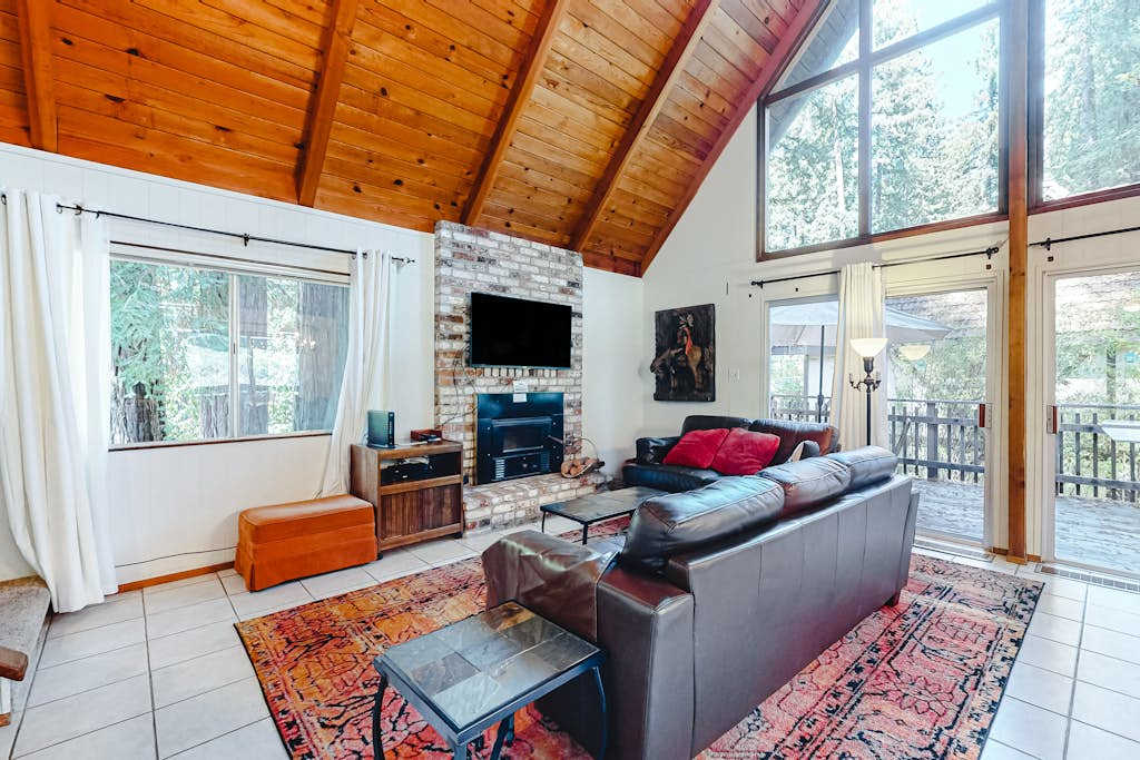 Gather around the wall-mounted TV after a day of wine tasting — your living room blends rustic redwood charm with cozy modern comforts.