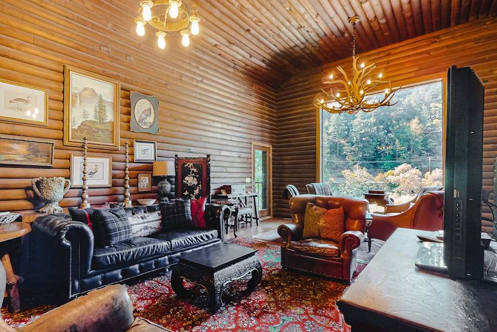 Sink into leather sofas under a showpiece antler chandelier — vaulted log ceilings and a panoramic window frame your Russian River retreat perfectly.