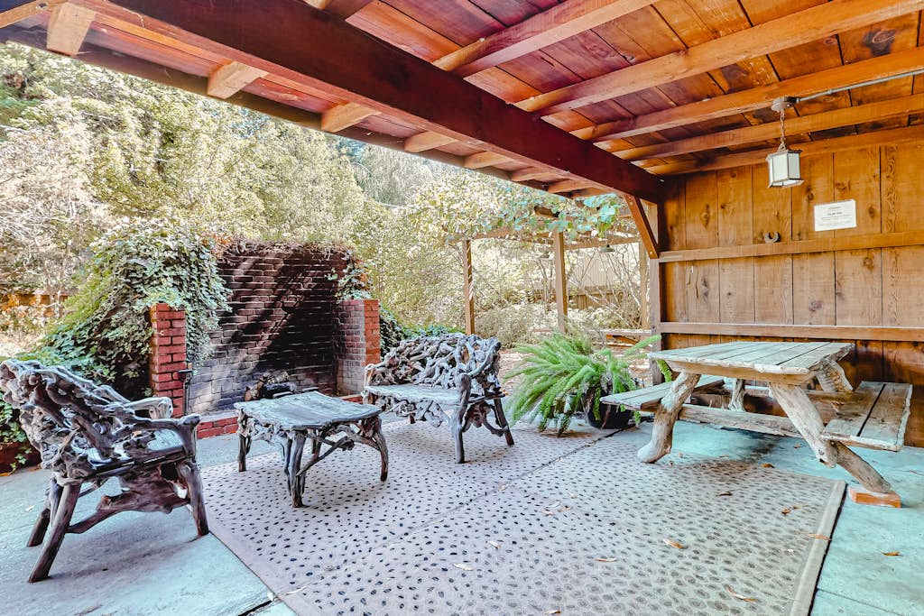 Unwind beneath your private covered patio — wrought-iron seating, a brick hearth, and a picnic table set the scene for lazy redwood afternoons along the Russian River.