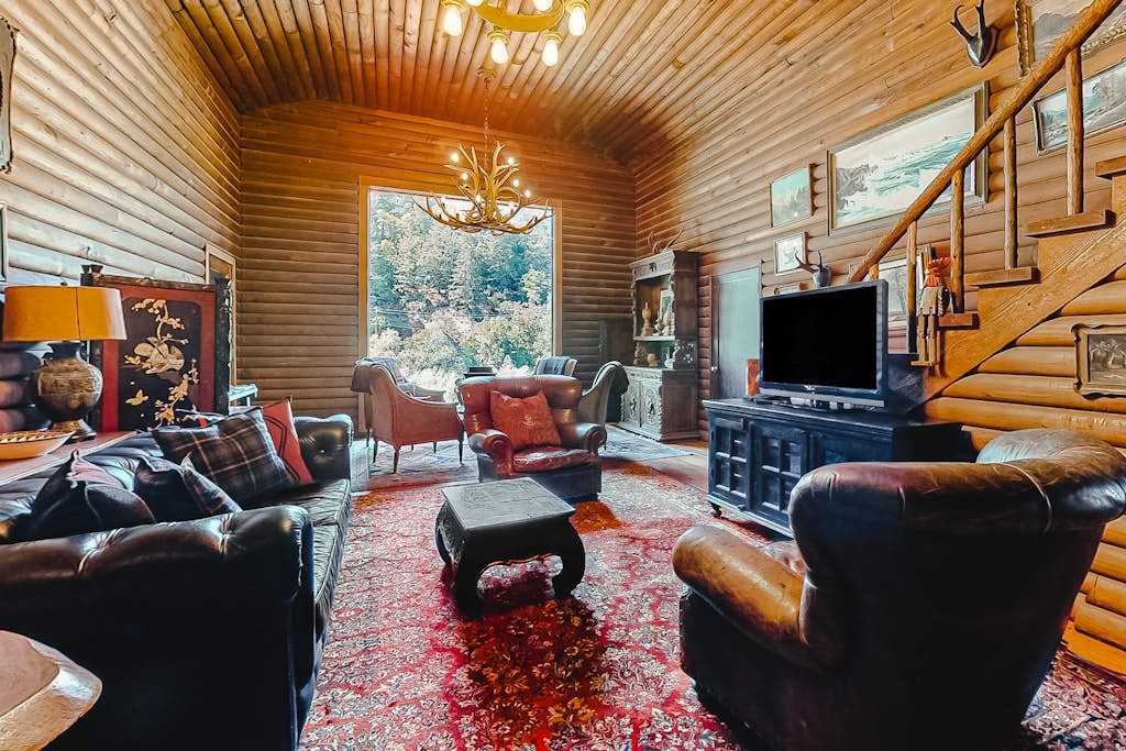 Gather your group around the flatscreen after a day of Sonoma wine tasting — plush seating, a loft staircase, and warm log walls wrap you in lodge comfort.