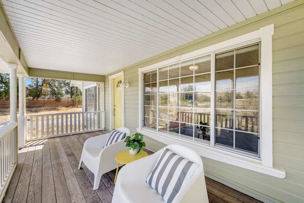 Morning coffee tastes better on your covered front porch — striped-pillow loungers face the Healdsburg countryside, inviting you to slow down and sip.