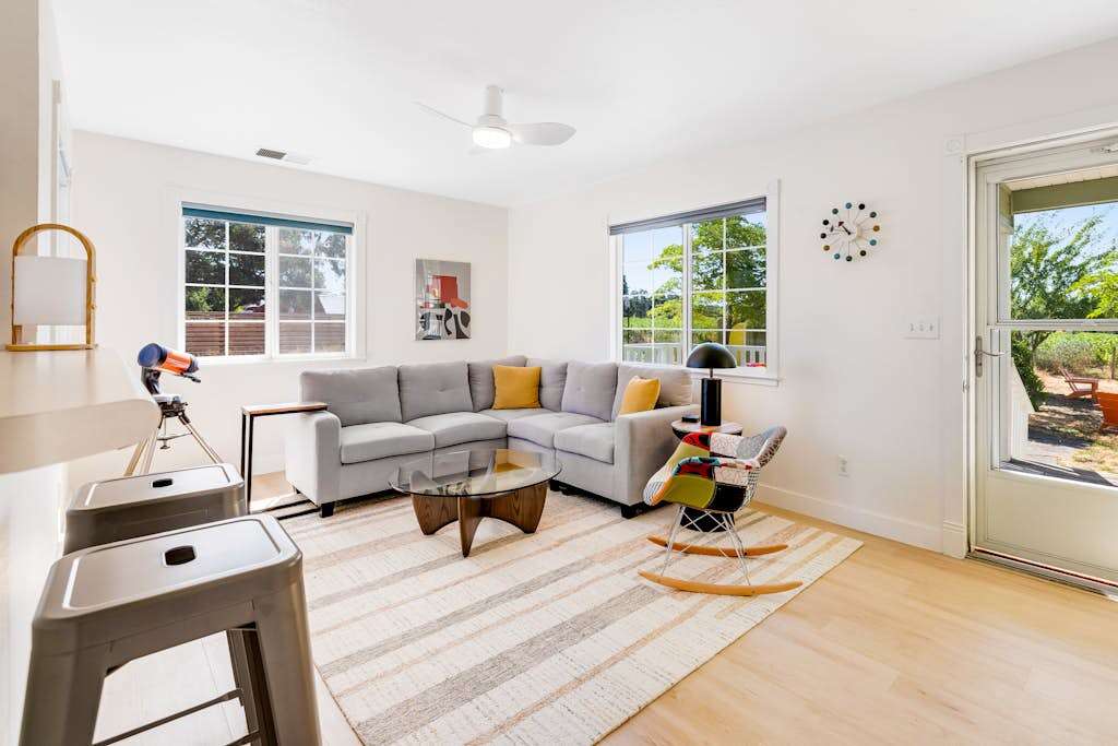 Sink into your sun-filled living room after a day of Healdsburg tasting rooms — plush sectional, modern accents, and natural light pouring through every window.