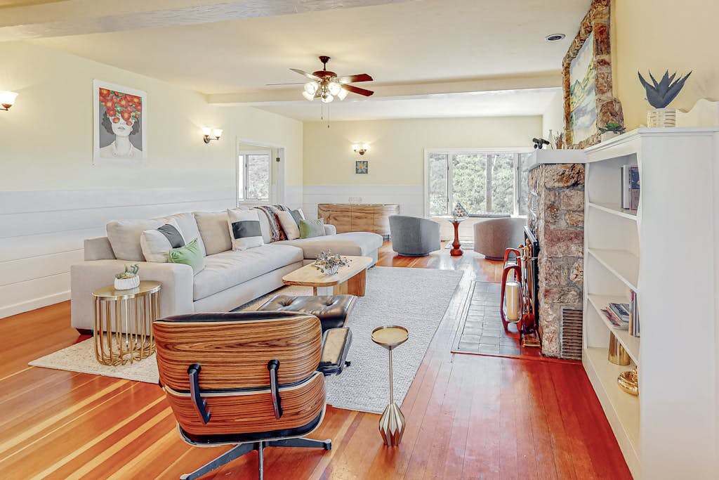 Warm mid-century style meets Healdsburg charm — settle into the iconic lounge chair beside a stone hearth while afternoon light spills across gleaming hardwood floors.