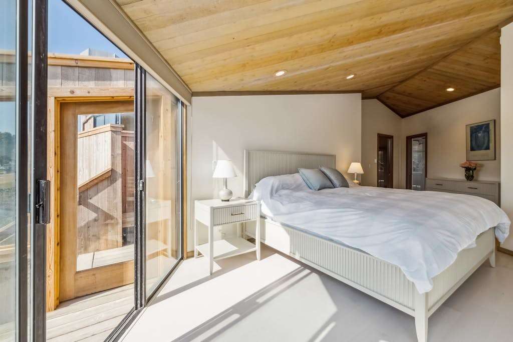Morning light streams across your king bed through sliding glass doors—step outside onto the deck before breakfast and breathe in the salt air