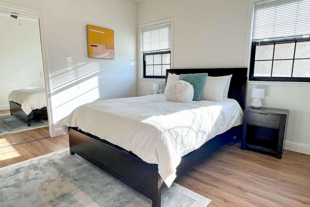 Bright and airy, your third bedroom features a queen bed with crisp white linens and accent pillows — natural light streams through double windows for a refreshing Penngrove morning.