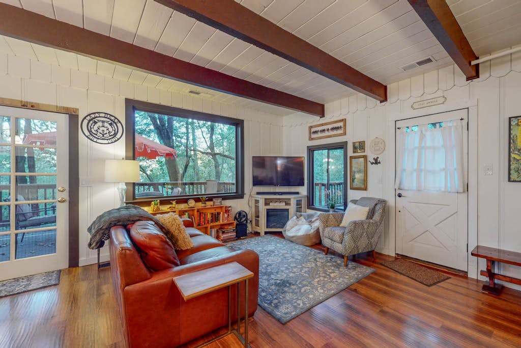 Sink into the leather sofa after a day of Forestville wine tasting — exposed timber beams, hardwood floors, and forest views through oversized windows make your living room a true retreat.