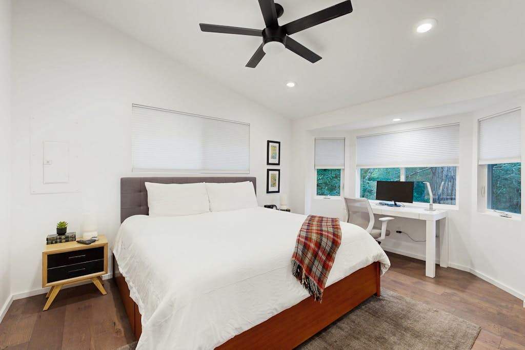 Drift off in the king bedroom under a whisper-quiet ceiling fan — crisp white linens and a work desk await your Healdsburg retreat.