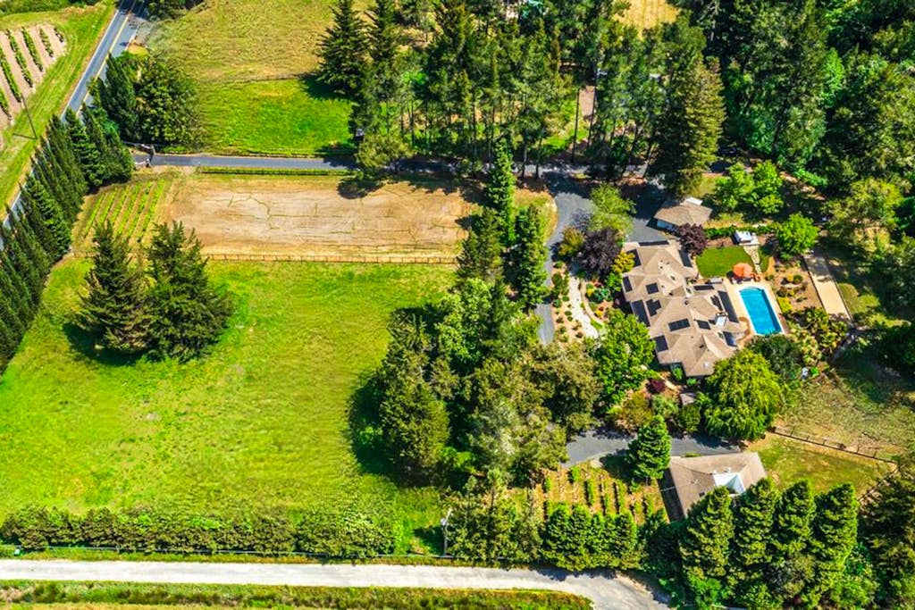 Nestled among Sonoma vineyards, your estate sprawls across lush grounds with a private pool, guest cottage, and event barn — a true wine country compound