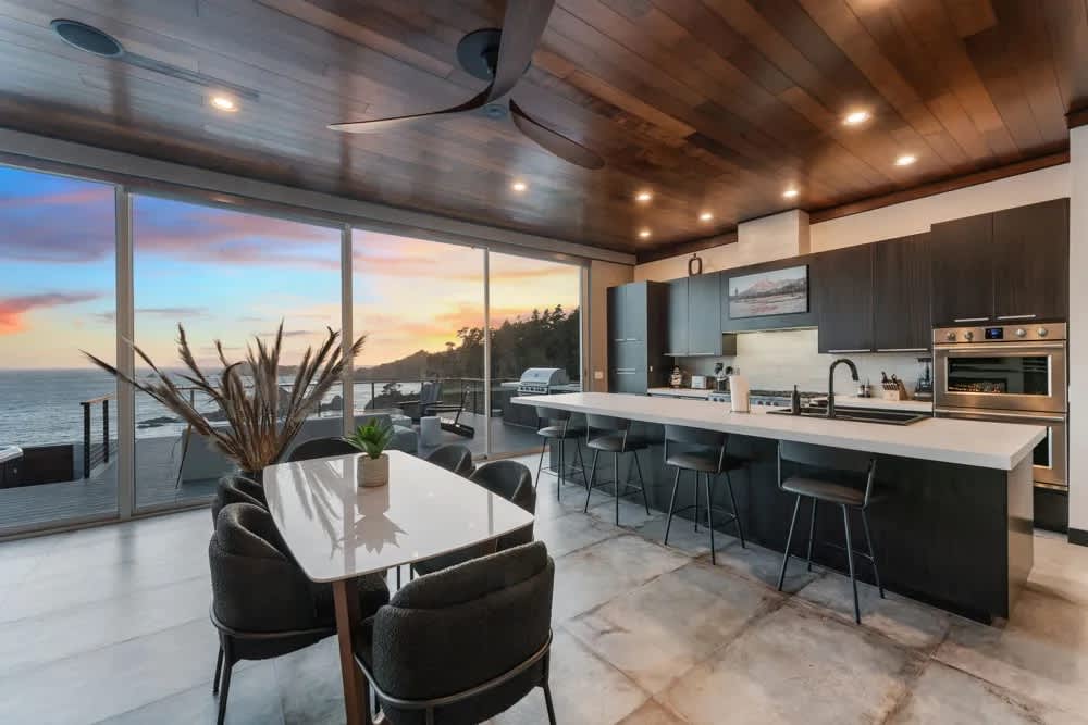 Dinner for six at the marble table while the sunset runs the length of the glass. The deck is one slider away.