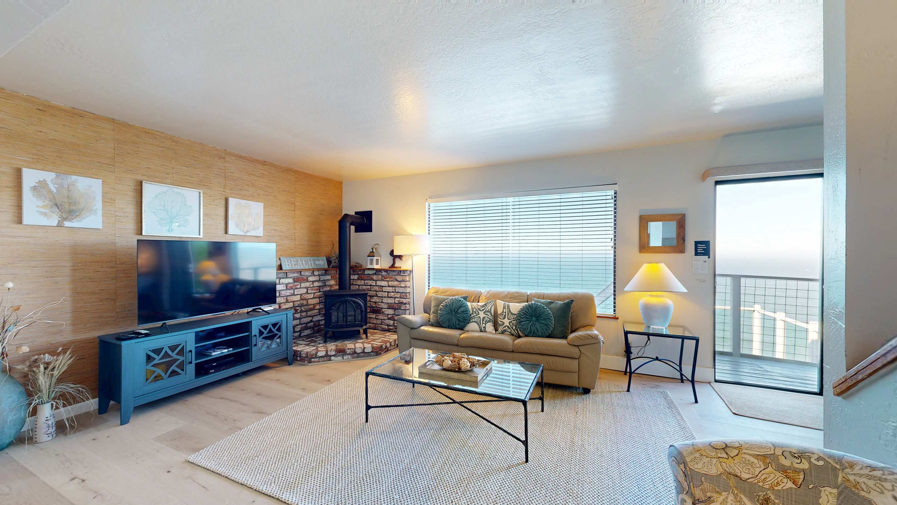 A big-screen TV, gas fireplace, and bamboo accent wall give the living room a laid-back coastal feel -- the sliding glass door puts the ocean one step away.