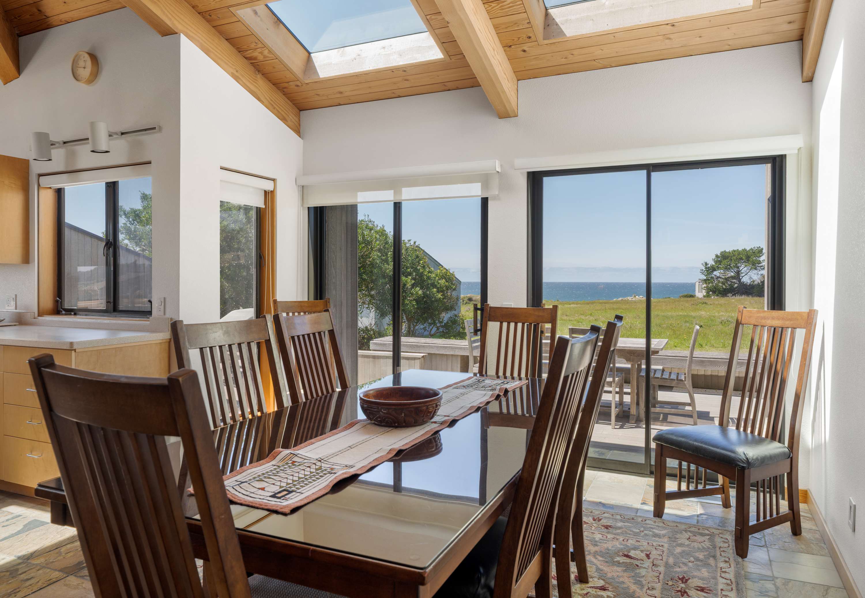 Gather around the dining table beneath skylights, where ocean views through the glass doors make every meal feel like a special occasion.