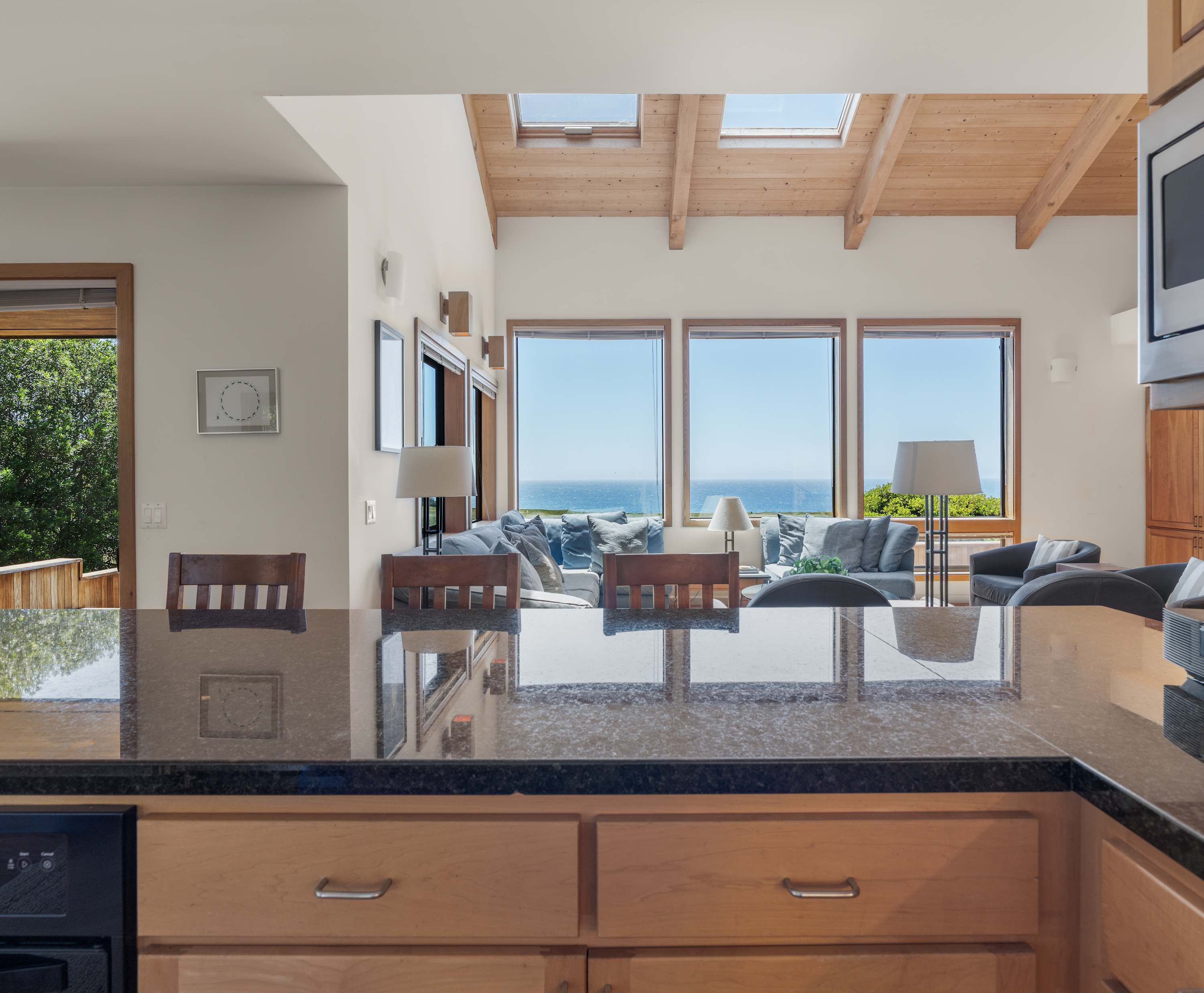 Granite island with a sightline straight to the surf — pour wine for friends without missing a single sunset off the bluff.