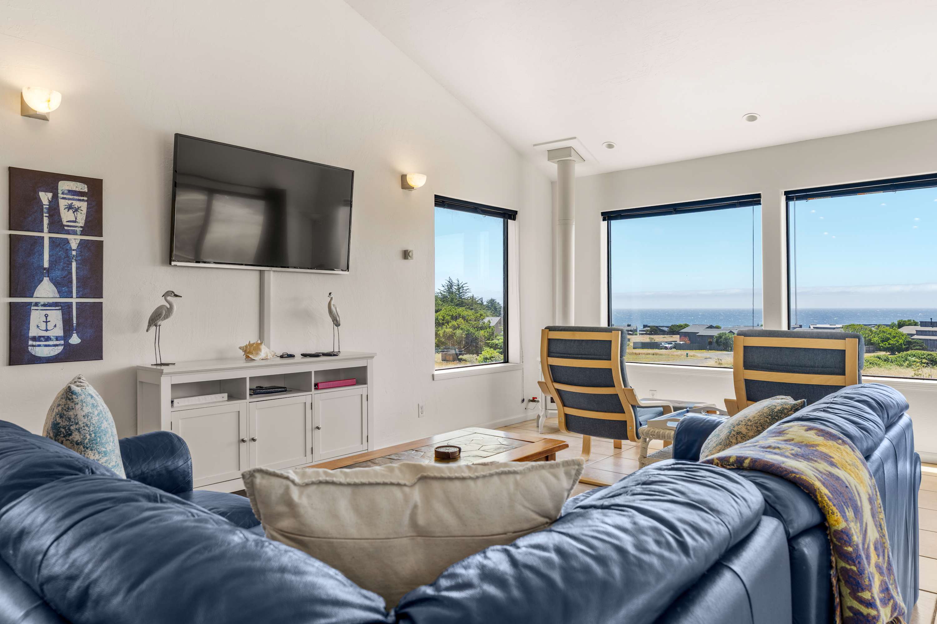 Gather on the deep leather sofa for movie night, then glance up to find ocean blue framed in nearly every window of this airy great room.