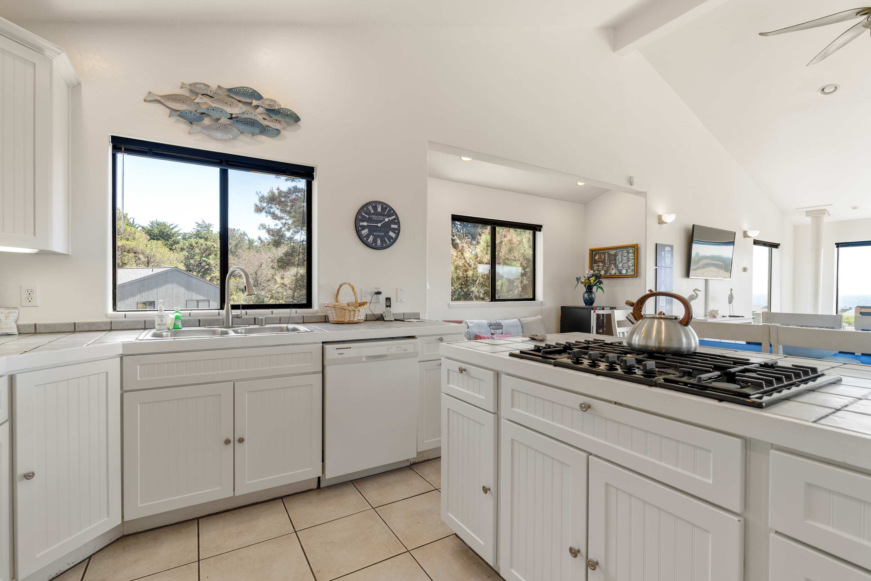 Brew your morning coffee in the bright tiled kitchen, where a window over the sink frames the treetops and the great room stays in easy view.