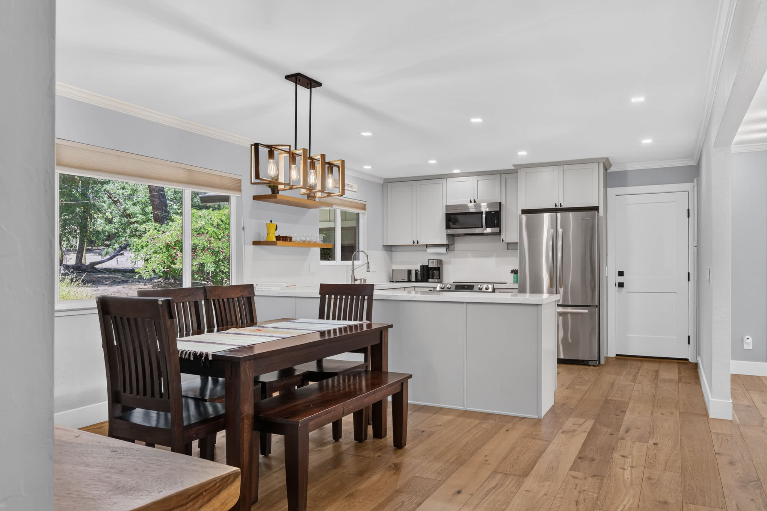 Gather six around the dark wood farm table while the chef works the quartz island, lit by an Edison-bulb chandelier.