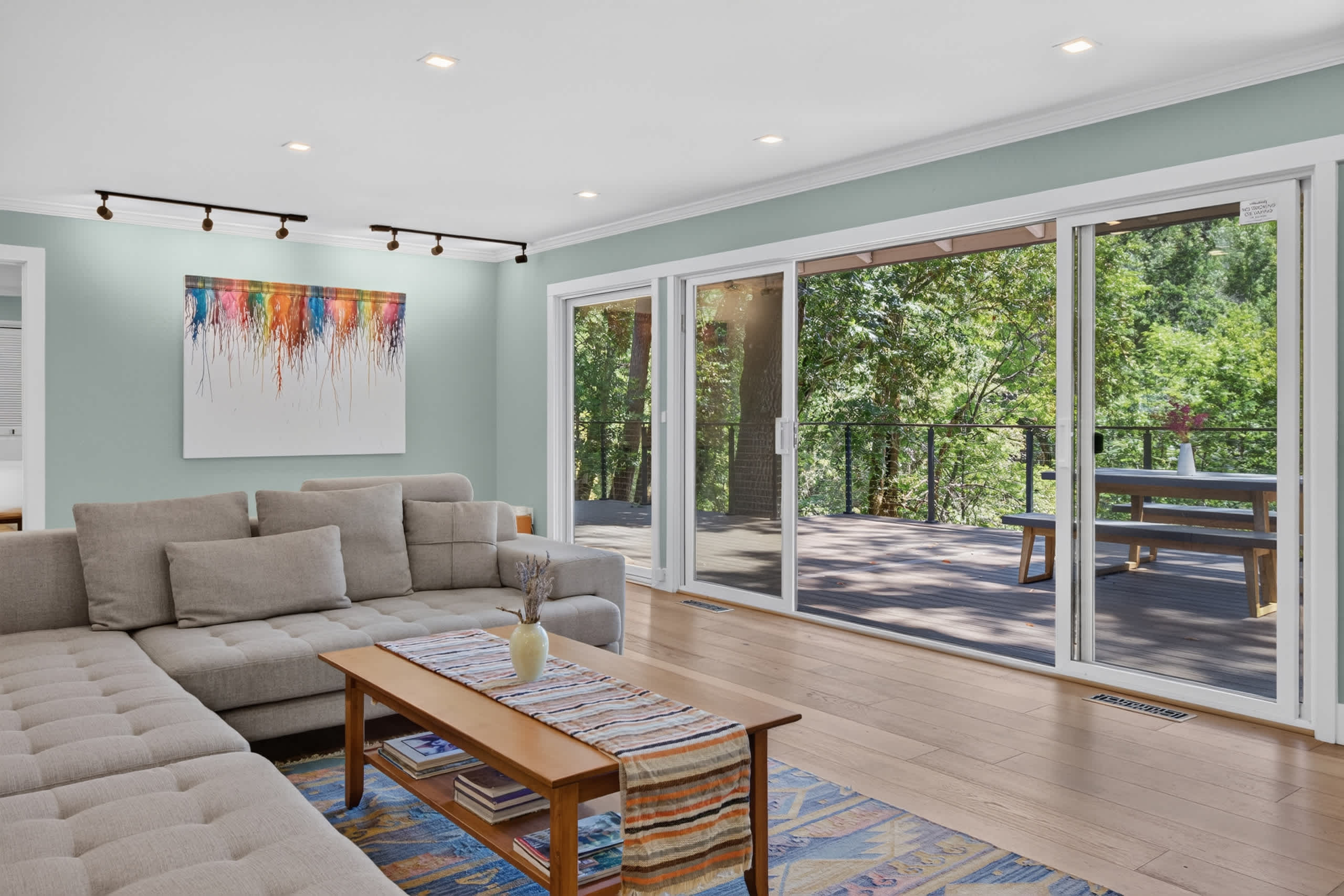 Stretch out on the tufted chaise with a kilim rug underfoot, surrounded by sage walls, splashy canvas art, and forest views.