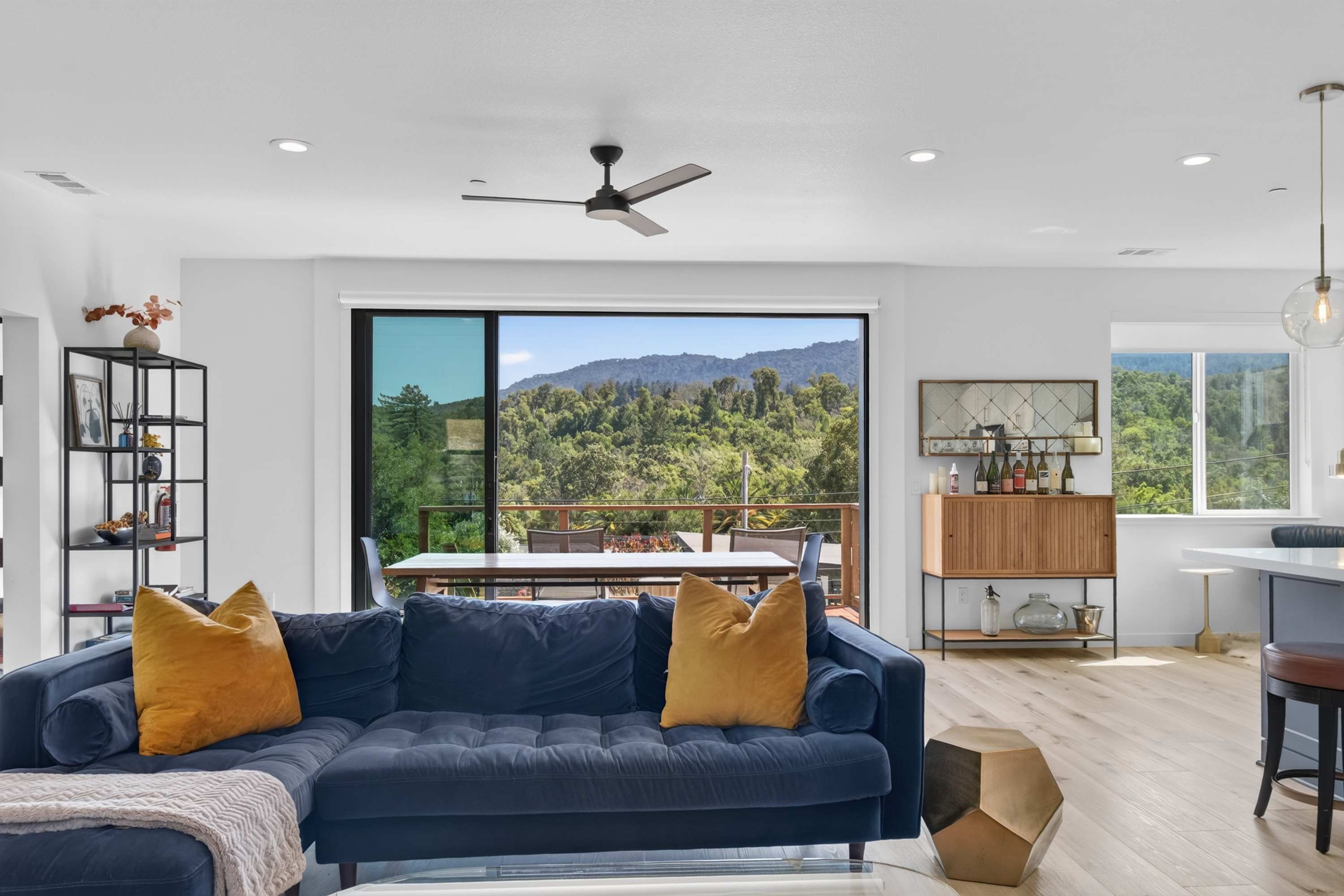 Slide open the glass doors and the living room flows straight onto the deck, with Mt. Tam framed beyond the sofa.