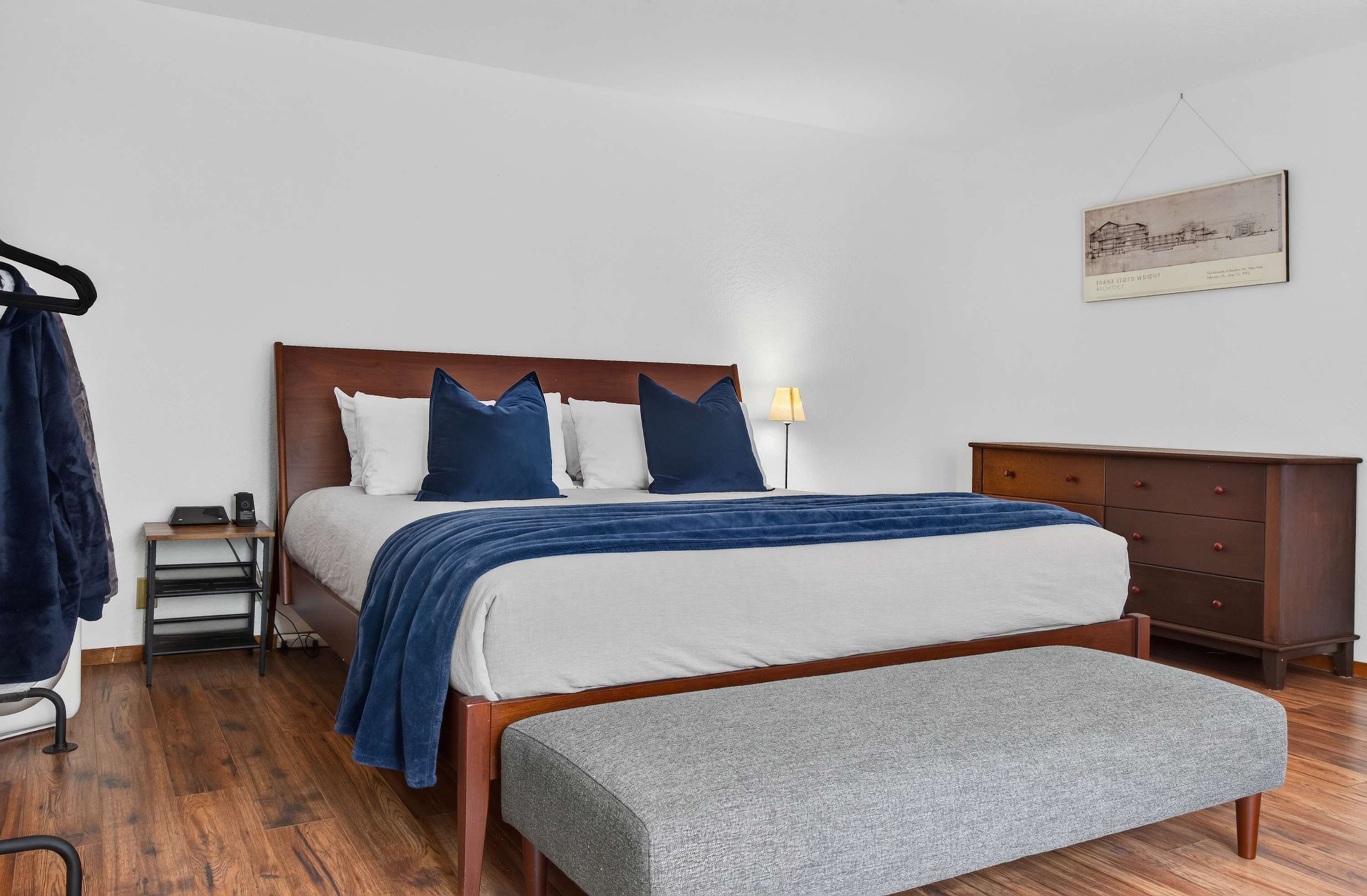 Stretch out on the king bed dressed in navy velvet, with a bench at the foot and warm hardwood underfoot for easy mornings.