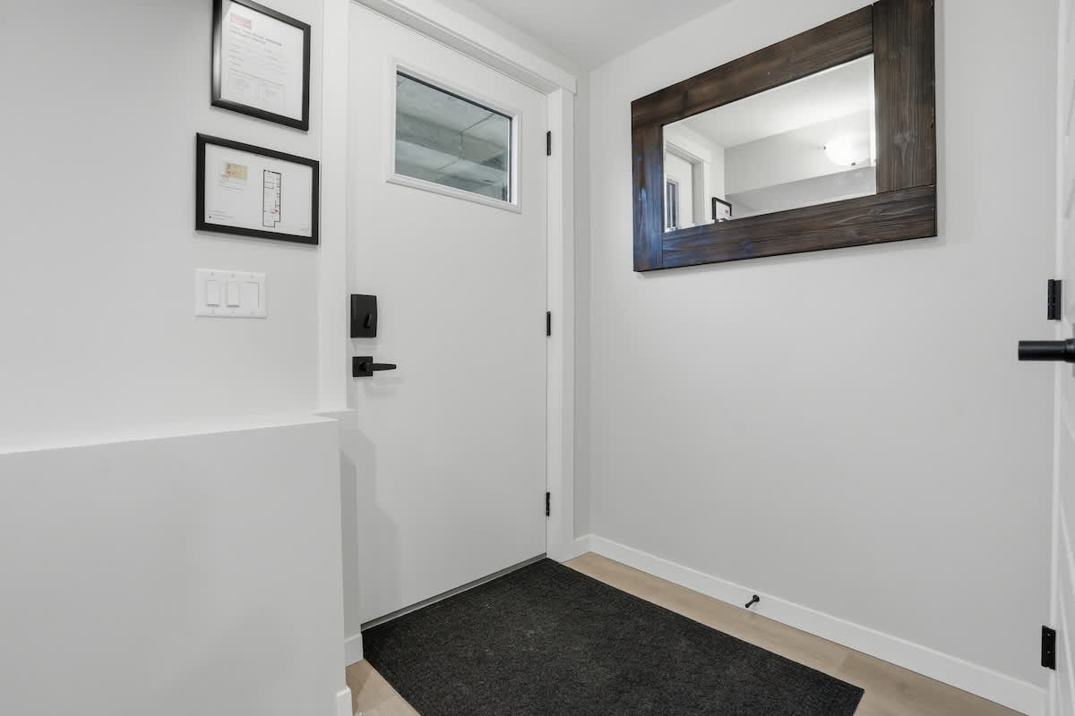Front door entrance with mirror and fire escape plan. 