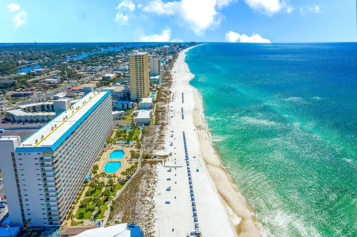 The Summit 921 – Aerial view of The Summit 921, featuring beachfront, pools, and high-rise buildings along a sandy coastline.