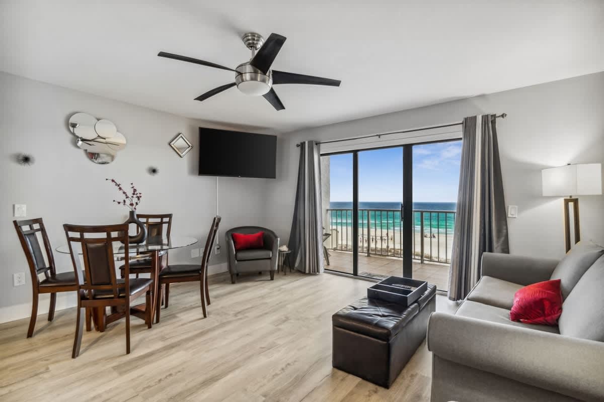 The Summit 531 – Living room with ocean view, seating area, dining table, and flat-screen TV.