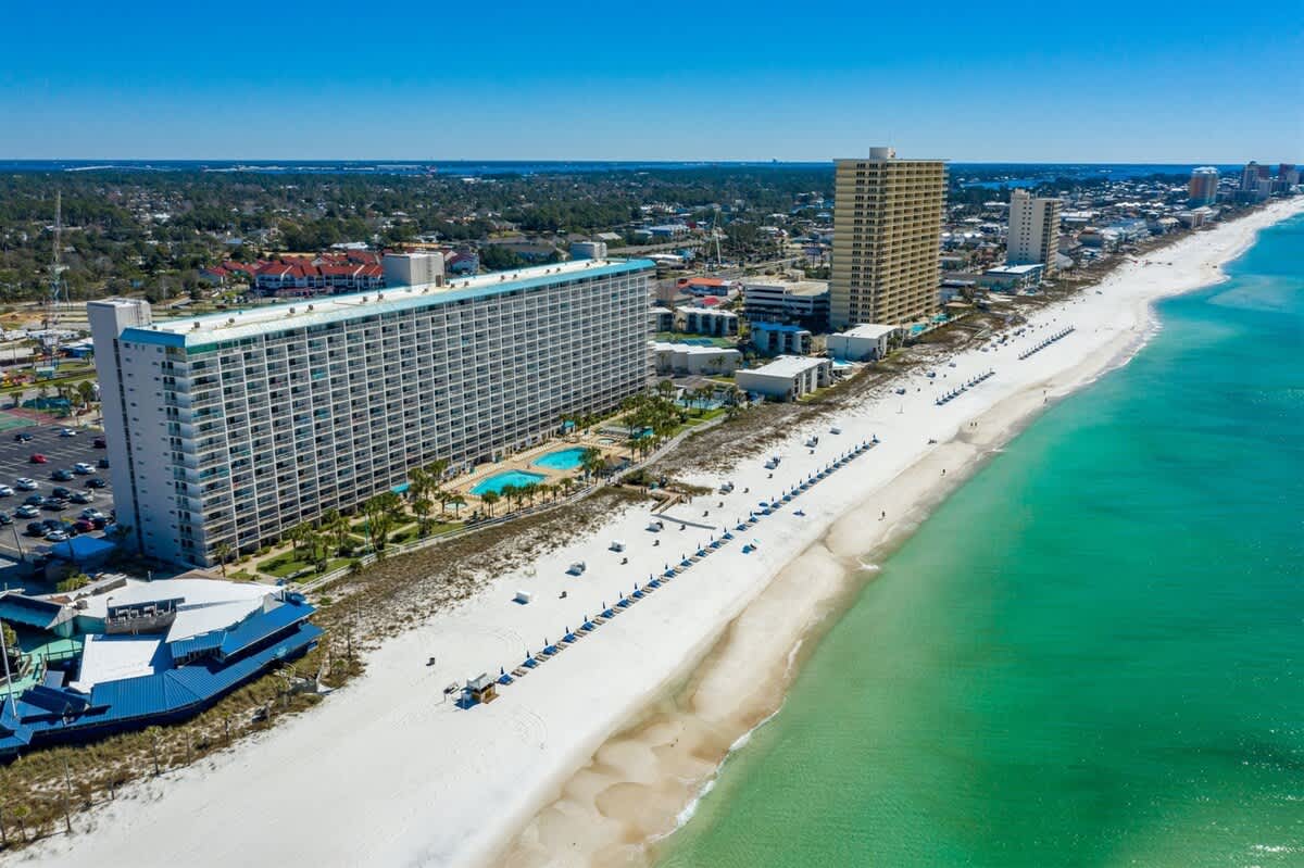 The Summit 531 – Aerial view of a beachside building with a pool and white sandy beach.