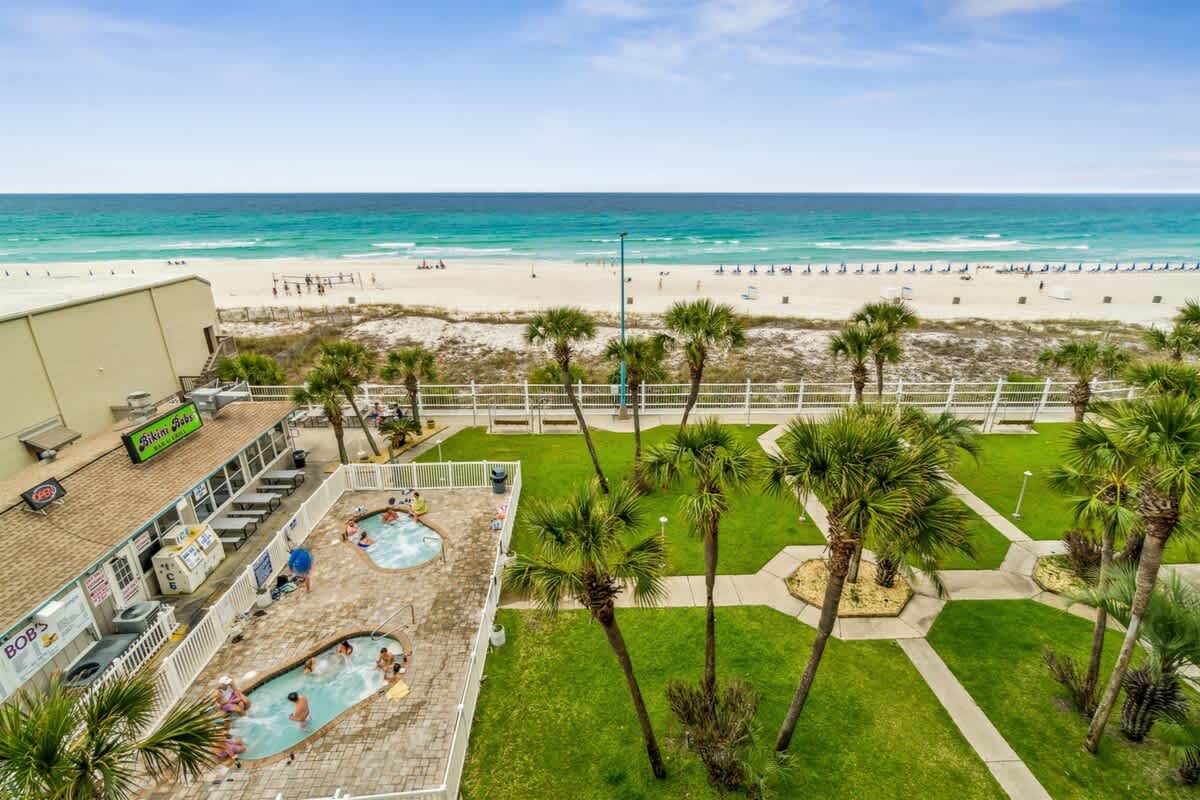 The Summit 531 – View of beach, hot tubs, and palm trees from a balcony.
