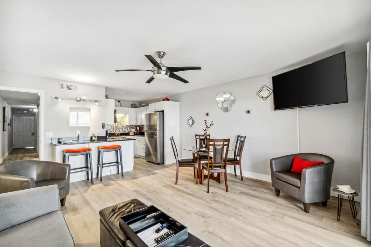 The Summit 531 – Open living area with kitchen, dining table, seating, and wall-mounted TV.