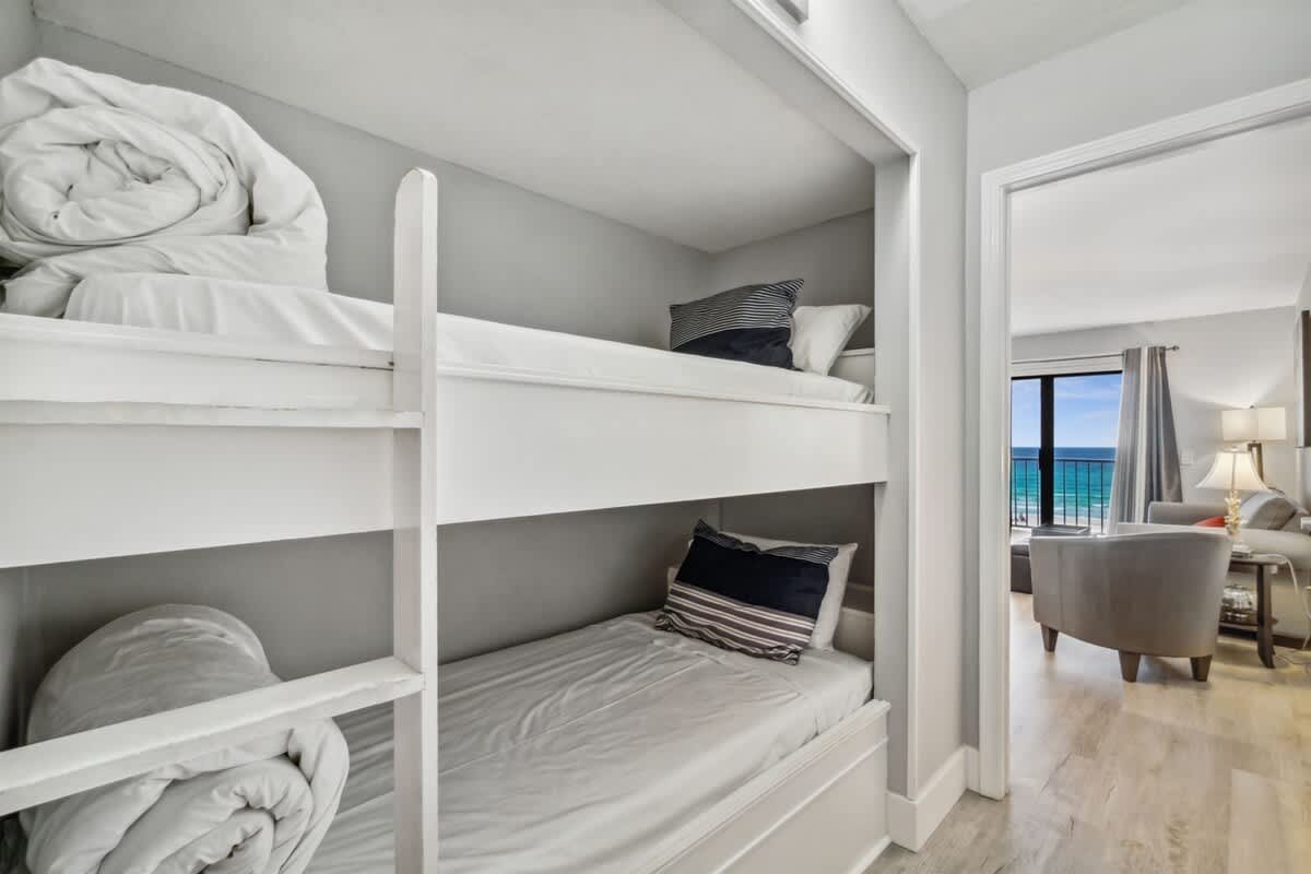 The Summit 531 – Bunk beds in a vacation rental with a view of the ocean and comfortable seating area.