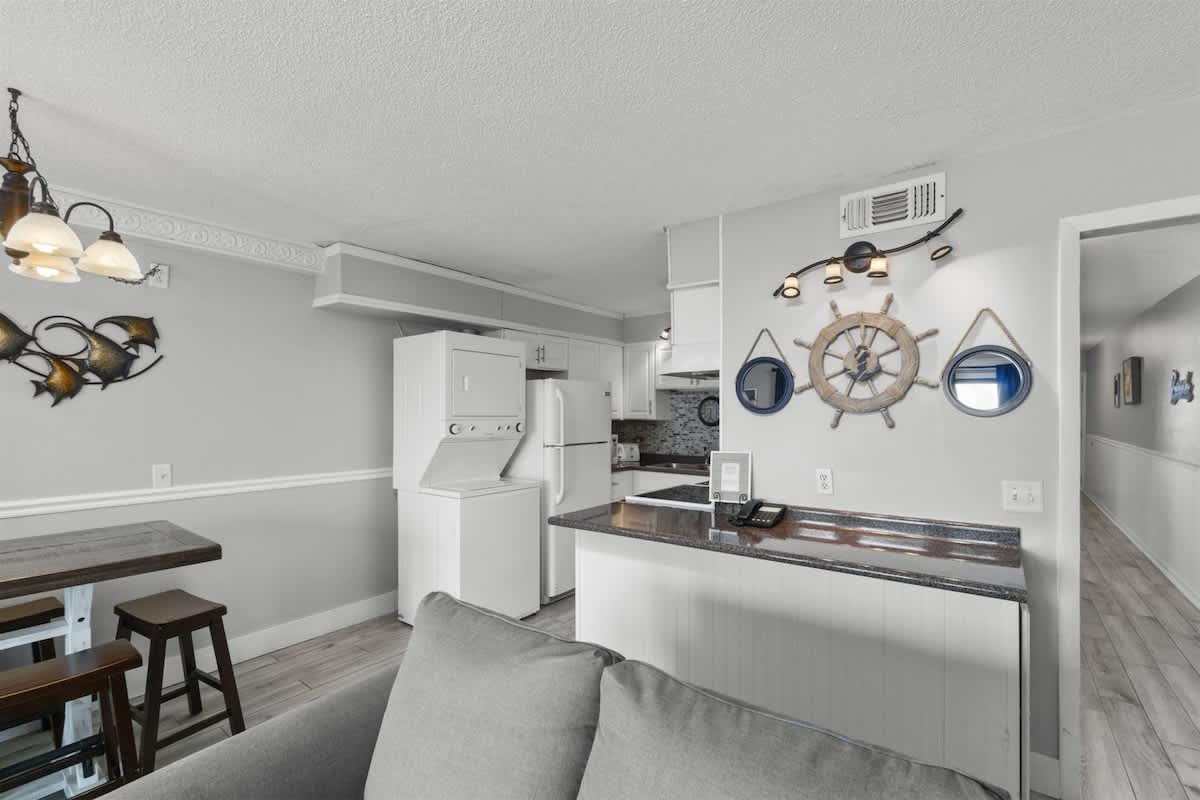 The Summit 728 – Cozy kitchen area with seating, appliances, and decorative nautical elements. Light-colored walls and flooring.